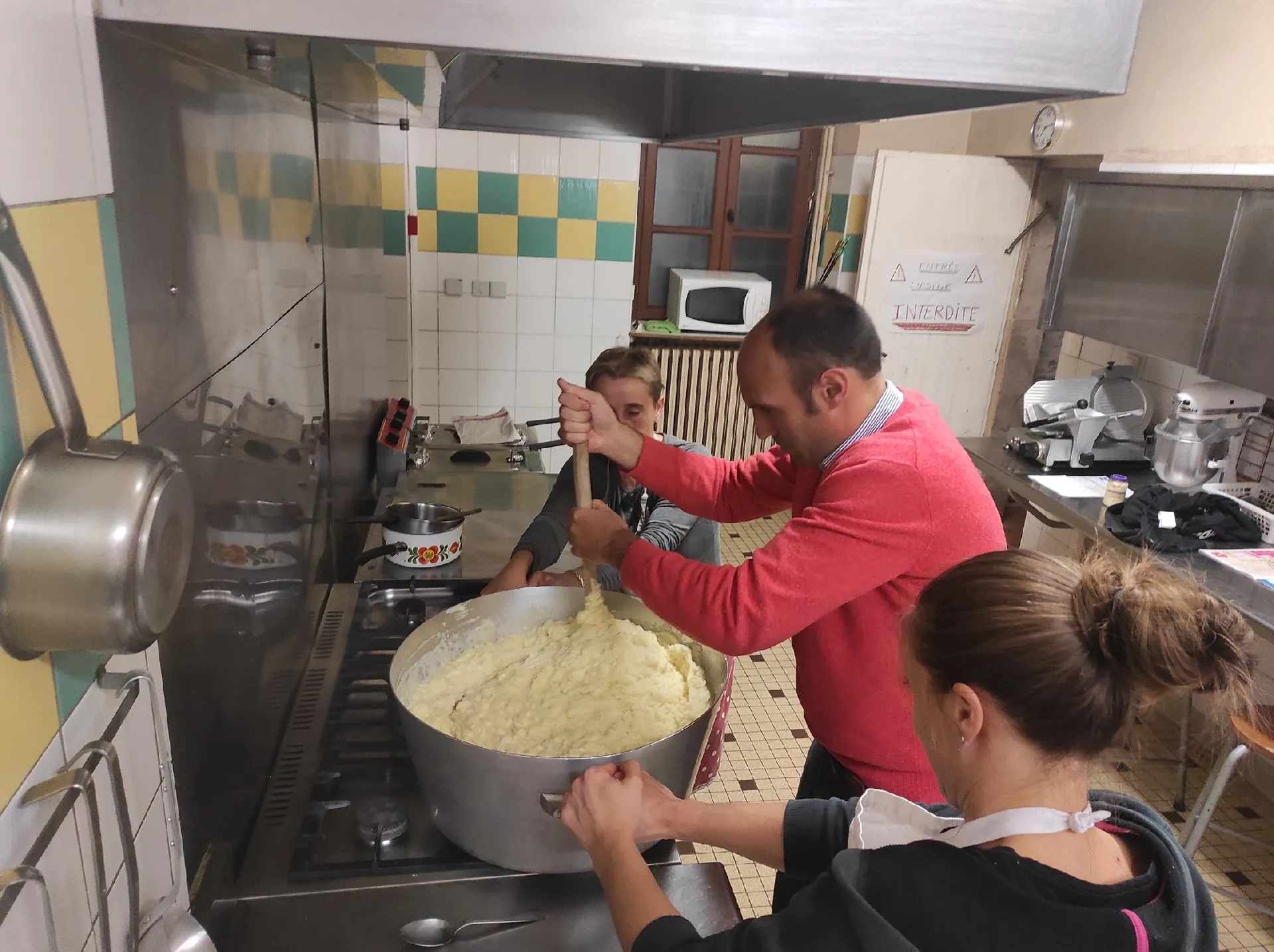 Un pélerin chanceux tourne l'aligot avec nos cuisinières